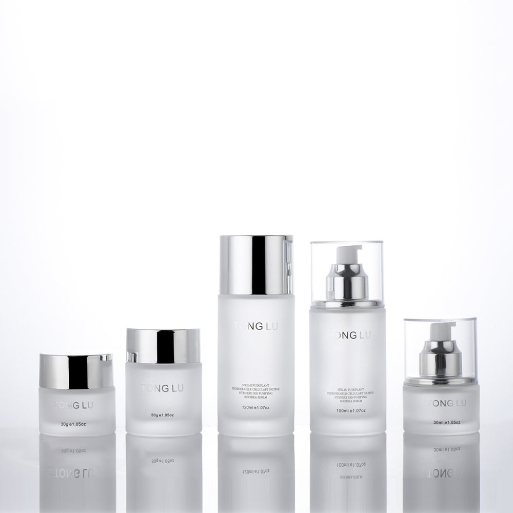 Ready-to-ship cosmetic glass bottle set packaging, including 30ml pump-style essential oil dispensing bottles and 30g glass jars for skincare creams and lotions